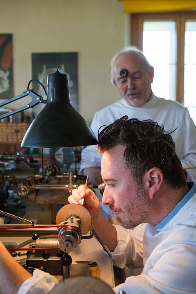 Picture of Philippe Dufour transmitting traditional watchmaking skills to Hervé Schlüchter
